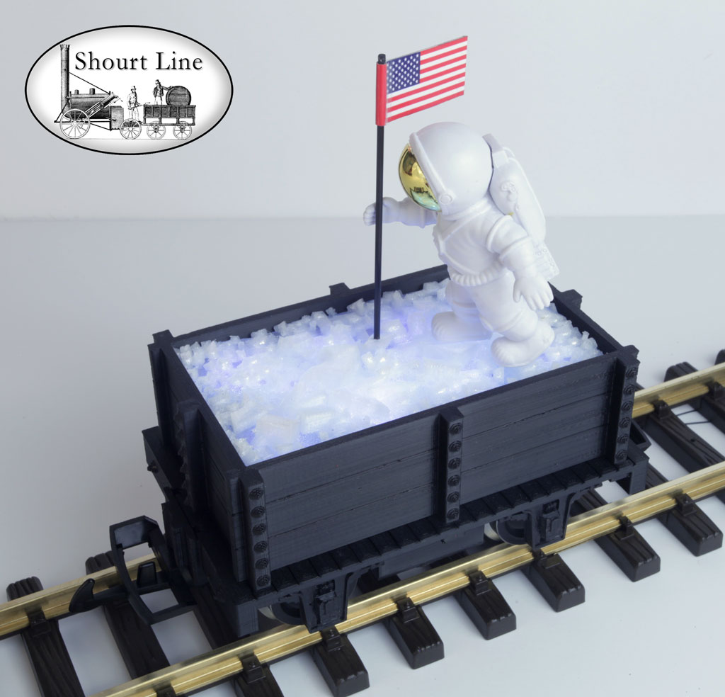 SL 9011139 4th of July Mini-Max Gondola with Ice load lighed by 11 White LEDs, with an Astronaut planting an American Flag on the ice, Track powered, PIKO Metal Wheels LGB Couplers SL WalkWay-Coupler, Assmebled & Wired - Ready to Run NEW - Lighted - On the track left front elevated view